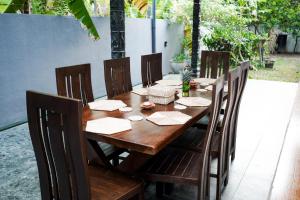 a wooden table with wooden chairs and a tableablish at Ocean Life Ayurvedic Villa in Talalla South