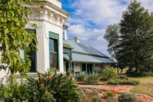 an old white house with a green roof at Lochinvar House in Lochinvar