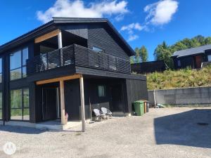 a black house with a balcony on top of it at Pia Apartment in Bykle