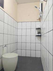 a white tiled bathroom with a tub and a shower at Gia's Baguio Transient House in Baguio +37 photos