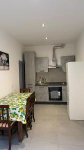 a kitchen with a table with chairs and a refrigerator at Le Case di Stela in Terni