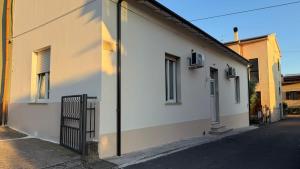 a white building with a gate next to a street at Le Case di Stela in Terni +2 photos