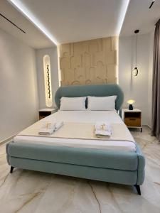 a bedroom with a large bed with a blue headboard at Casa Palma Villa in Velipojë