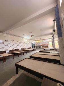 a large room with rows of tables and benches at DANGWAL HoTEL in Srīnagar
