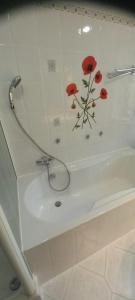 a bath tub with red flowers painted on the wall at Landgut Pinnow in Murchin +38 photos