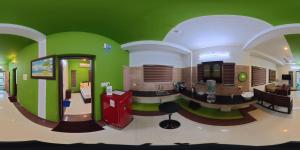 a room with a kitchen with green walls at J V A Home stay Apartment Hotel in Kollam