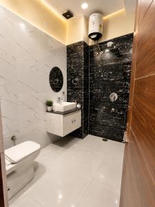a bathroom with a toilet and a sink and a shower at Hotel Woodlark Heights Zirakpur Chandigarh !! Family Hotel ! Easy Airport Access ! Budget Friendly in Chandīgarh +18 photos