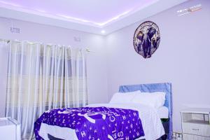 a bedroom with a purple and white bed and curtains at 7Palms Executive Lodges in Ndola