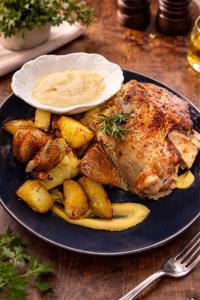 a plate of food with meat and potatoes on a table at Hotel Metro in Kłodzko