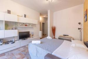 a white bedroom with a bed and a television at Borgo House, Bologna by Short Holidays in Bologna