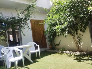 two white chairs and a table in a yard at Villa des jasmins in Kelibia