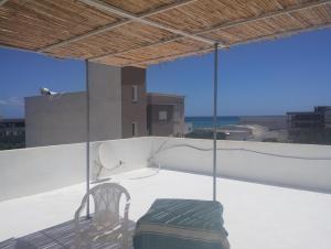 a chair sitting on a balcony with a view of the ocean at Villa des jasmins in Kelibia