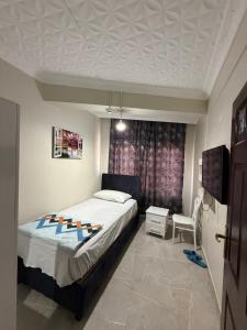 a bedroom with a bed and a window at Girasun otel in Jesıret ibn Omar