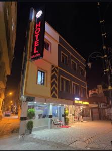 a building with a sign on the side of it at Girasun otel in Jesıret ibn Omar