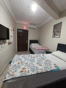a room with two beds and a tv in it at Girasun otel in Jesıret ibn Omar