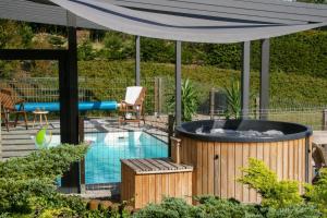 a patio with a hot tub and a pool at Wyspa Kaszubska dom wypoczynkowy z sauną i balią in Lipnica