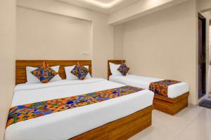 a bedroom with two beds and a window at FabHotel SB Palace in Nashik