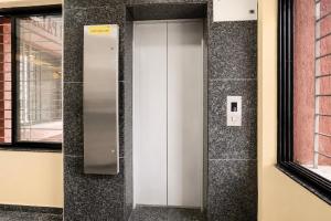 an elevator in a building with a wall at FabHotel SB Palace in Nashik