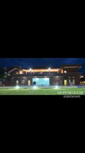 a view of a building at night with lights at Dn FARM HOUSE in Moinabad