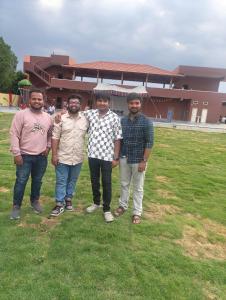 a group of four men standing in a field at Dn FARM HOUSE in Moinabad