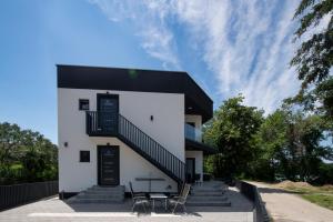 a white house with stairs and a table and chairs at Vila Dominus Lux in Veliko Gradište
