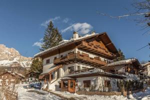 a house in the snow in front of a mountain at Cantore, Cortina by Short Holidays in Cortina dʼAmpezzo