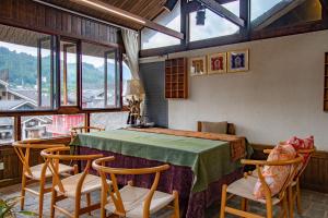 a room with a table and chairs and windows at Zhangjiajie Yun Hai Hotel- Ancient Chinese Style Hotel,Tea Culture Experience, Realxing Class,Free Breakfast ,Local Travel Guide and Book Tickets, Gem Perporty in Zhangjiajie