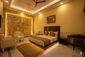 a bedroom with a bed and a desk and chairs at Aaram Baagh Maheshwar in Maheshwar +36 photos