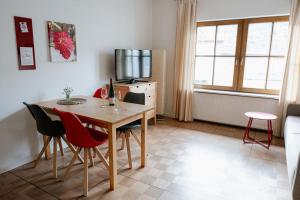 a room with a table and chairs and a television at Claes Weinquartier - Appartements & Wein by Niko Schmitt in Trittenheim +33 photos