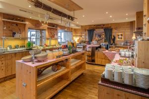 a large kitchen with wooden walls and wooden floors at Hotel Alpenfriede in Sölden