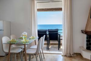 a dining room with a table and a view of the ocean at Corfu Dream Holidays Villas in Glyfada