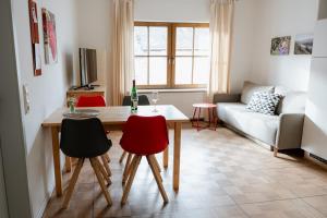a living room with a table and chairs and a couch at Claes Weinquartier - Appartements & Wein by Niko Schmitt in Trittenheim