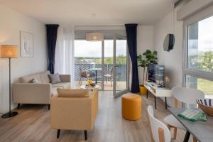 a living room with a couch and a table with chairs at DOMITYS - Les Quernons in Trélazé