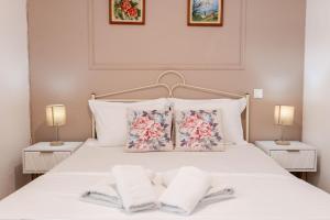 a bedroom with a white bed with two towels on it at Corfu Dream Holidays Villas in Glyfada