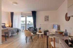 a kitchen and living room with a bed and a table at DOMITYS - Les Quernons in Trélazé