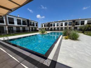 a swimming pool in front of a building at Liza Evren Sitesi in Manavgat