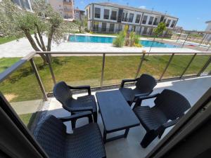 a balcony with chairs and a table and a pool at Liza Evren Sitesi in Manavgat