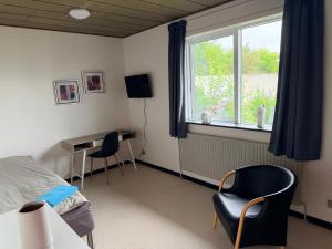 a bedroom with a bed and a desk and a window at Room for rent Solskrænten in Vorgod