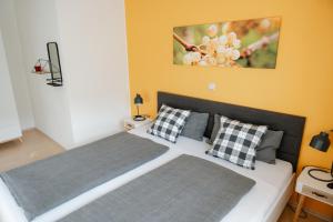 a bedroom with a large bed with two pillows at Claes Weinquartier - Appartements & Wein by Niko Schmitt in Trittenheim