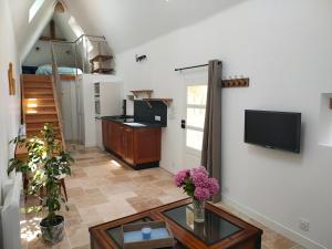 a living room with a tv on a wall at Authentic Breton penty in Penmarch