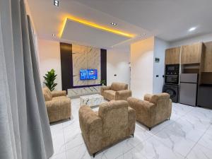 a living room with chairs and a tv in a room at Esthella Property in Ijaiye