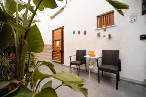 two chairs and a table in a courtyard with plants at Loca Centre Suites in Bodrum City