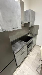 a stainless steel kitchen with a sink and a stove at La Casa di Stela 2 in Terni