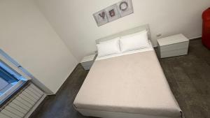 a small bedroom with a bed with white sheets and pillows at La Casa di Stela 2 in Terni