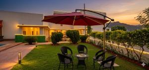 a patio with chairs and a table with an umbrella at The Vanashva in Tehla