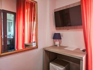 a room with a desk with a mirror and a window at Hotel Chrismare Taormina in Taormina