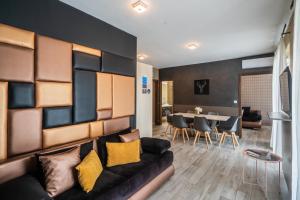 a living room with a couch and a table at AH-Corso Wellness Residence in Siófok
