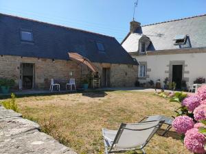 a couple of chairs sitting in the yard of a house at Authentic Breton penty in Penmarch