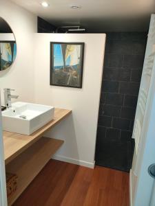 a bathroom with a white sink and a shower at Authentic Breton penty in Penmarch +3 photos
