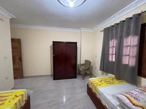 a bedroom with two beds and a door with a window at Newytr home in Kafr al Ishārah